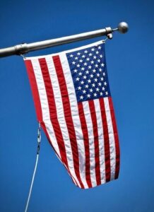 american flag waving in front of a blue sky